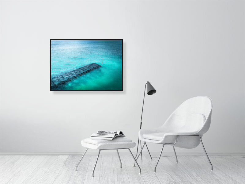 Blue waters of Lancing beach with remains of some wooden structure. Print or framed photography art.