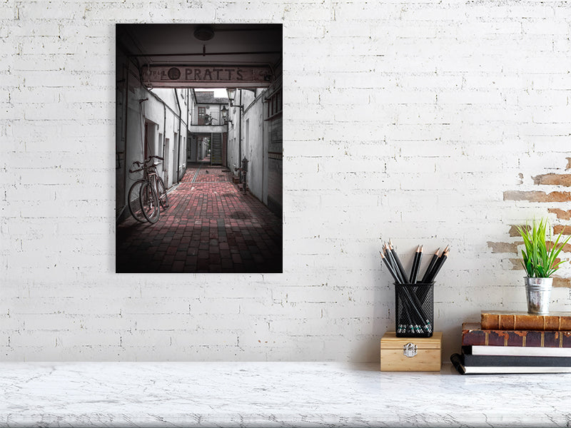Quiet alleyway with vintage bicycle parked up. Print or framed art photography.
