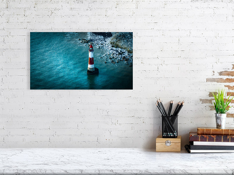 Lighthouse in blue waters of Eastbourne just off the cliff of Beachy Head, Eastbourne, East Sussex, UK