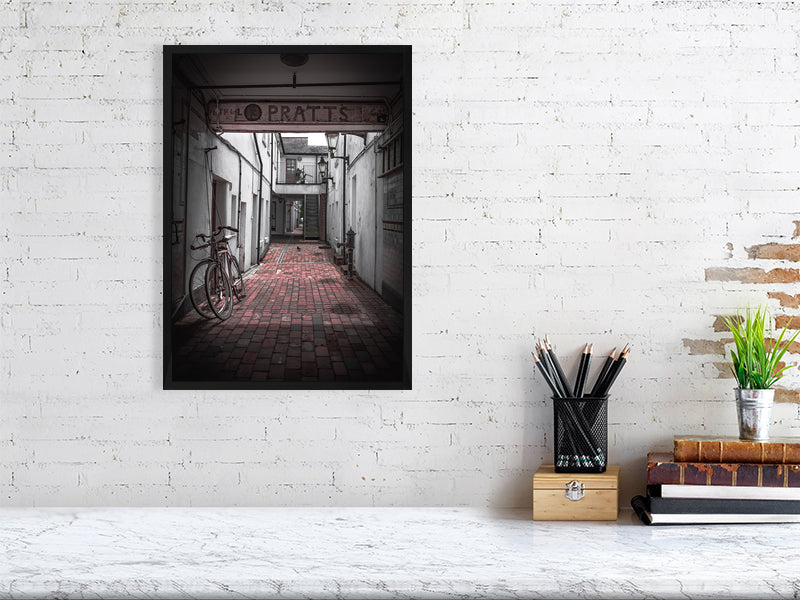 Quiet alleyway with vintage bicycle parked up. Print or framed art photography.