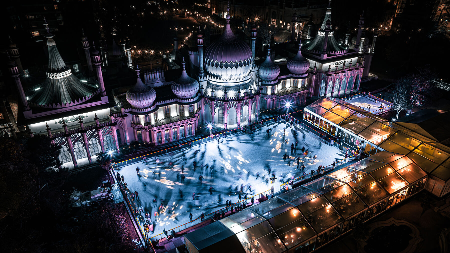 Aerial view of Brighton Royal Pavilion on a cold winter night, ice skaters on center stage. Printed or framed photography art.