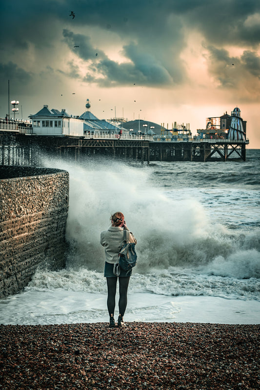 Random spectator watching waves on a windy autumn day by Brighton Pier. Print or framed photography art.