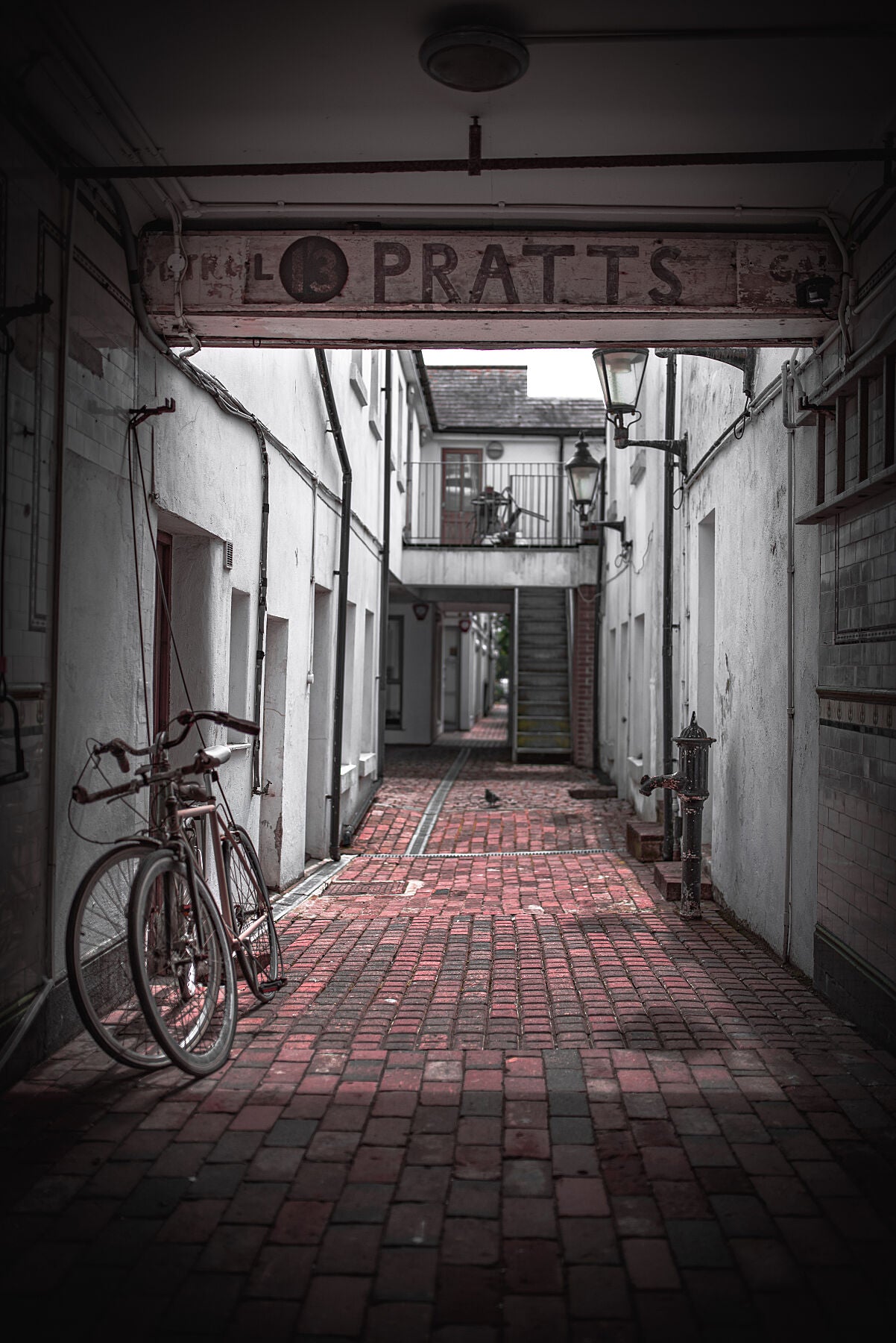Quiet alleyway with vintage bicycle parked up. Print or framed art photography.