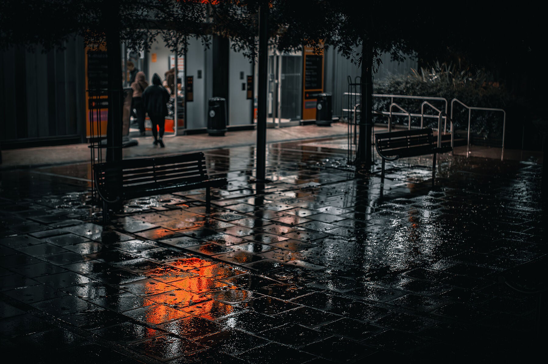 Neon light reflections on a wet pavement during heavy rain at night. Print or framed art photography.